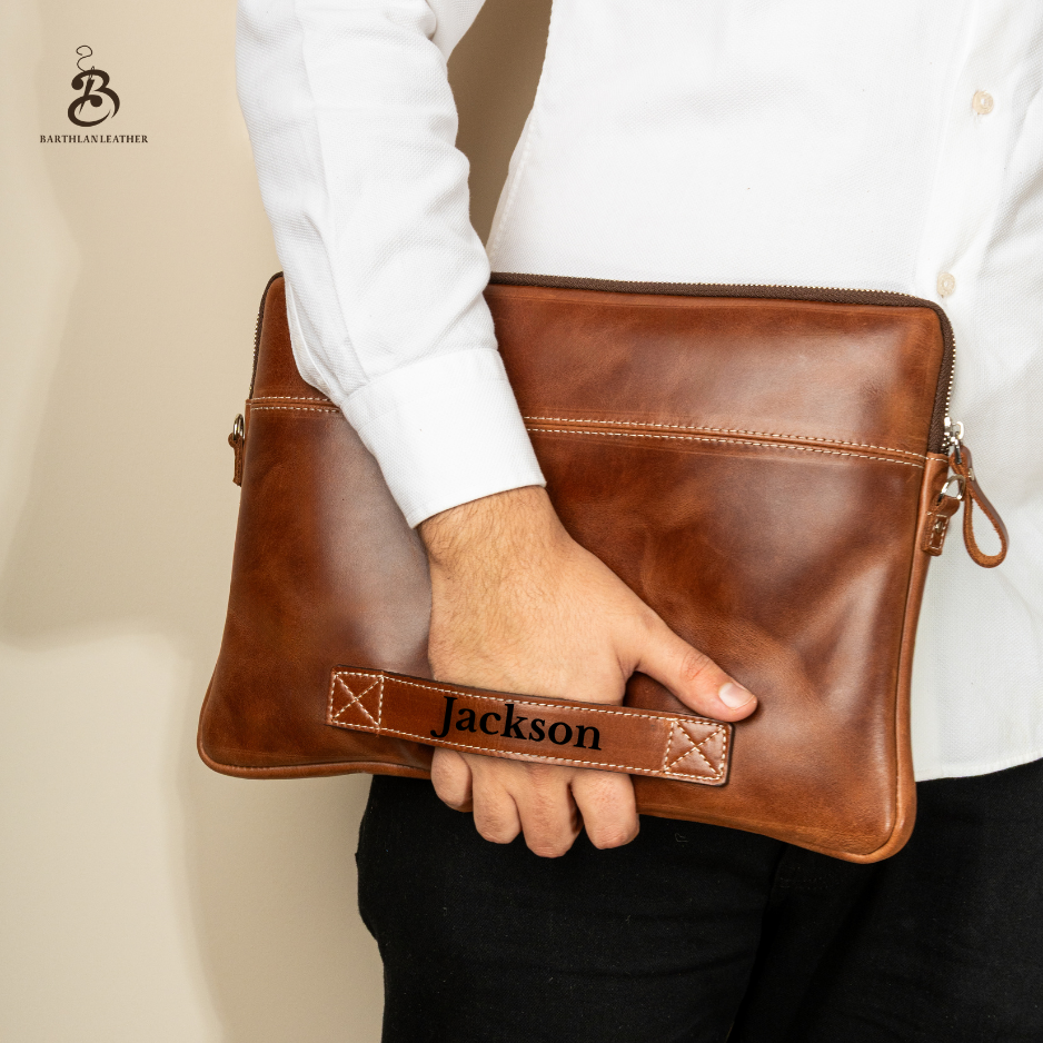 Man carrying a personalized chestnut laptop bag by its back handle