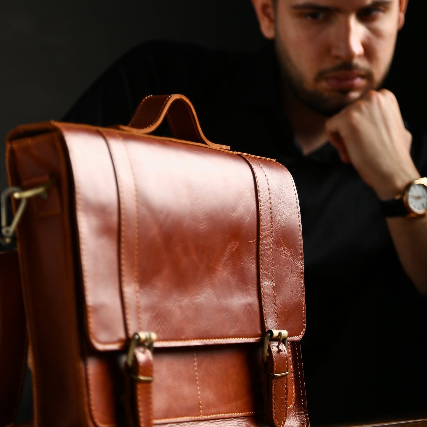Close-up of chestnut full grain leather briefcase and brass buckles