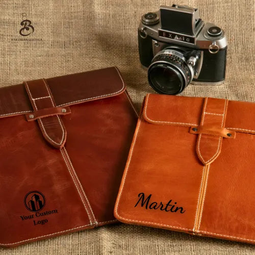 Camel and brown personalized leather iPad sleeves beside a vintage camera