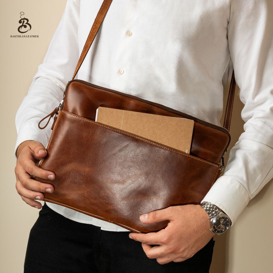 Man holding an open chestnut laptop bag with documents inside