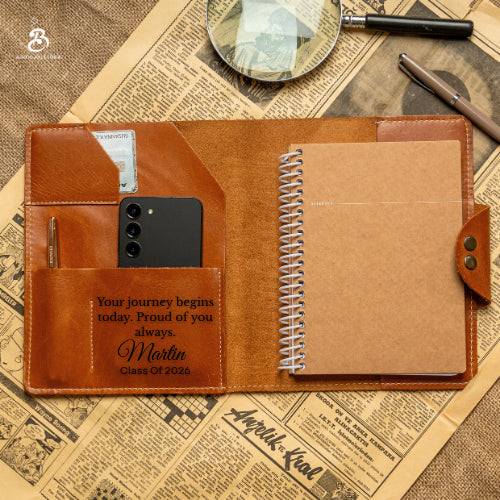 Personalized chestnut A5 portfolio open with notebook, cards, phone, and pen