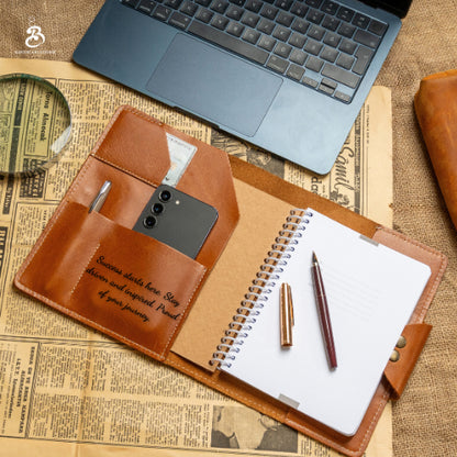 Open A5 leather portfolio beside a laptop and stationery