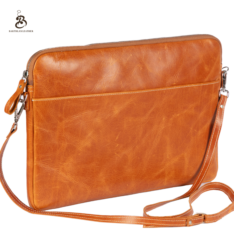 Front view of a camel leather laptop bag with shoulder strap