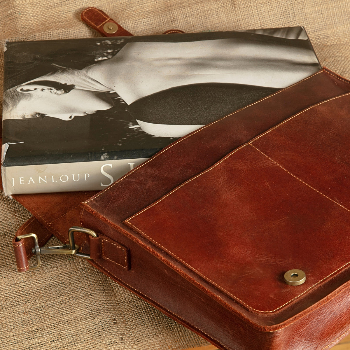 Open chestnut leather briefcase showing the magnetic flap closure and lining